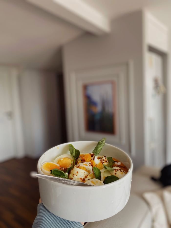 A fresh egg salad with basil and spices in a white bowl, perfect for a healthy meal.